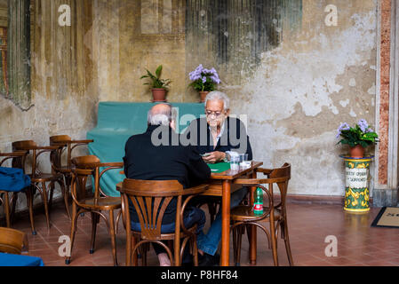 Sedile Dominova, un bâtiment historique avec une loggia ouverte avec fresques d'sert maintenant comme un working men's club, deux vieux hommes jouant aux cartes, Sorrento Banque D'Images