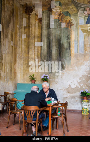 Sedile Dominova, un bâtiment historique avec une loggia ouverte avec fresques d'sert maintenant comme un working men's club, deux vieux hommes jouant aux cartes, Sorrento Banque D'Images