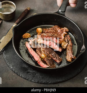 Tranches de rôti de bœuf juteux steak sur vintage la fonte poêle vue supérieure Banque D'Images