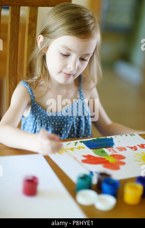 Cute little girl est le dessin avec de la peinture en maternelle Banque D'Images