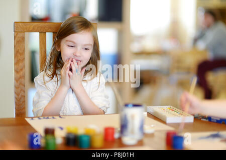 Cute little girl est le dessin avec de la peinture en maternelle Banque D'Images