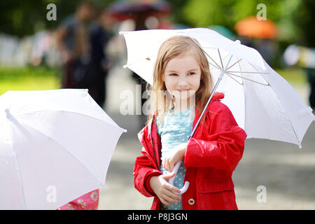 Adorable petite fille tenant parapluie blanc à jour de pluie en automne Banque D'Images