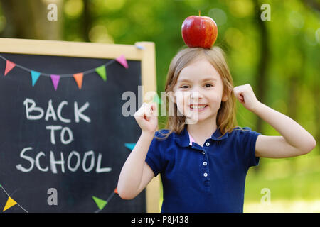 Adorable petit sentiment d'écolière ravie de retourner à l'école Banque D'Images