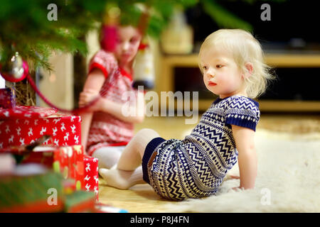 Deux adorables petites soeurs à cadeaux sous un arbre de Noël la veille de Noël à la maison Banque D'Images