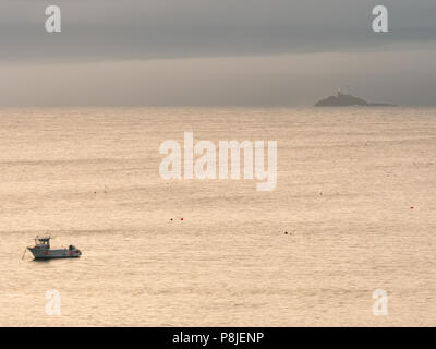 ST Ives, Angleterre - le 19 juin : un seul bateau de pêche avec le phare de Godrevy dans l'arrière-plan, au large de la côte de St Ives. À St Ives, Cornwall, Angleterre Banque D'Images