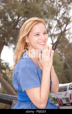 Une dame blonde sourire et détient ses mains Banque D'Images