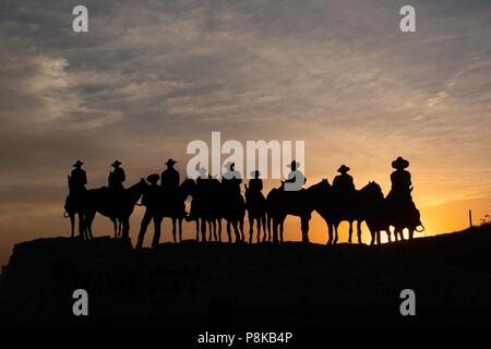 Sculpture silhouette de cow-boys à cheval au coucher du soleil à Dodge City, Kansas Banque D'Images