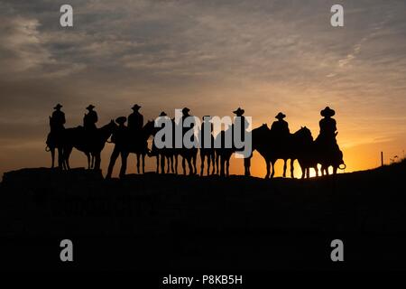 Sculpture silhouette de cow-boys à cheval au coucher du soleil à Dodge City, Kansas Banque D'Images