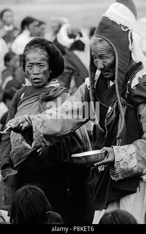 Un moine bénit les croyants avec des offrandes sacrées d'un crâne humain tasse à un festival bouddhiste tibétain dans la vallée de TARAP DOLPO N - DISTRICT, NÉPAL Banque D'Images