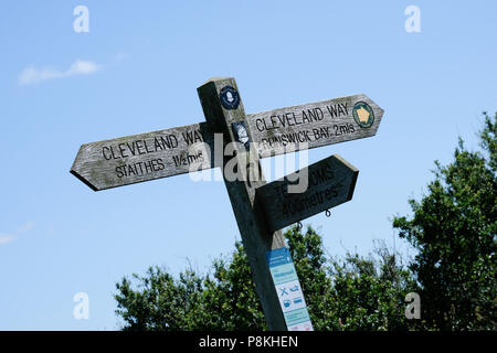 Inscrivez-post sur le Cleveland Way au-dessus de Port Mulgrave contre ciel bleu et arbustes Banque D'Images