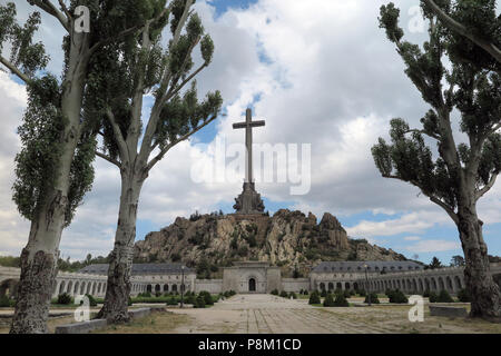 Déposée - 05 juillet 2018, l'Espagne, El Escorial : A 155 mètres de haut et 44 mètres de large croix en béton se dresse sur le haut de l'Risco de la Nava derrière l'abbaye bénédictine dans la Valle de los Caidos (vallée de la baissé). L'intérieur du monument à côté de Cuelgamuros près de El Escorial dans la Sierra de Guadarrama se trouve le tombeau du dictateur espagnol Francisco Franco et le fondateur de la Phalange, mouvement fasciste José Antonio Primo de Rivera. Il est connu comme l'un des plus grands mausolées plus récents du monde et le plus important symbole architectural de la dictature de Franco. À côté de la basilique, dans un lieu de culte, Banque D'Images