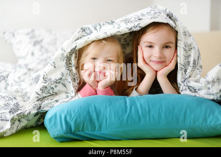 Deux petites soeurs jouant au lit sur matin ensoleillé Banque D'Images