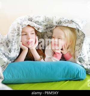 Deux petites soeurs jouant au lit sur matin ensoleillé Banque D'Images