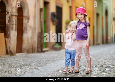 Deux mignonnes petites sœurs s'amuser en plein air, sur belle journée ensoleillée en ville italienne Banque D'Images