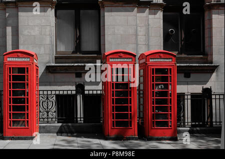 Les téléphones britanniques typiques de rouge boîtes téléphoniques contre un néo Bâtiment de bureau de poste classique en grès conçu par Henry Tanner in Preston Lancashire Banque D'Images