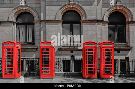 Les téléphones britanniques typiques de rouge boîtes téléphoniques contre un néo Bâtiment de bureau de poste classique en grès conçu par Henry Tanner in Preston Lancashire Banque D'Images