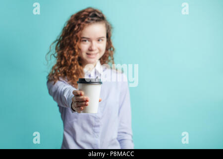 La photo en gros plan de red-haired fille de l'école propose du café. donner du café, du thé. copy space Banque D'Images