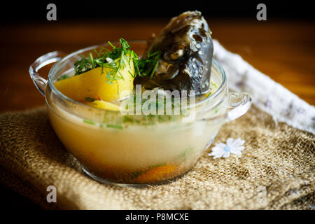 Soupe de légumes avec le poisson dans un bol en verre Banque D'Images