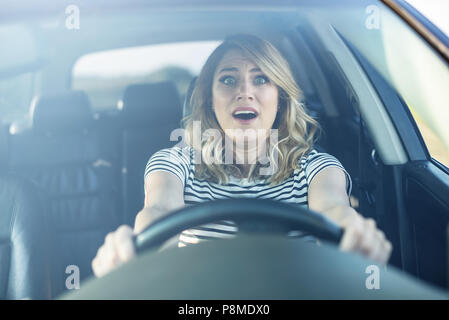 La femme au volant de la voiture dans une panique. Banque D'Images