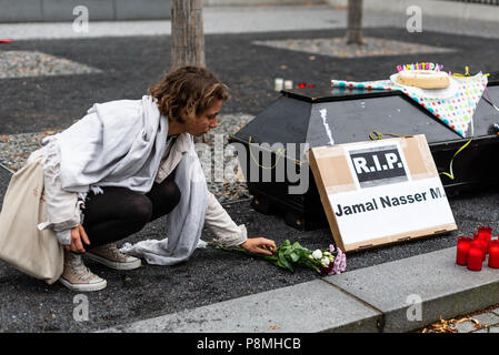 Un militant connu de déposer des fleurs à côté d'un cercueil. Protestation devant les militants du ministère fédéral de l'intérieur au cours de la veillée pour la réfugié afghan Jamal Nasser M. à l'âge de 23 ans, s'est enlevé la vie après avoir été expulsé d'Allemagne en Afghanistan. Ministre fédéral de l'Intérieur allemand, Horst Seehofer, a fait des plaisanteries à propos de cette déportation pendant la présentation du Plan directeur de la migration. Banque D'Images