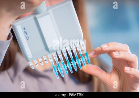 Chercheur en laboratoire microbiologique femme avec pipette multicanaux test ADN va Banque D'Images