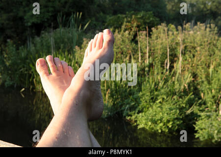 Pieds et se détendre au bord de la rivière sur une soirée de fin d'été dans le sud de l'Angleterre. En 2018. Banque D'Images