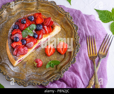 La moitié du gâteau au fromage aux fraises sur une plaque de cuivre de fer et deux fourches, vue d'en haut Banque D'Images