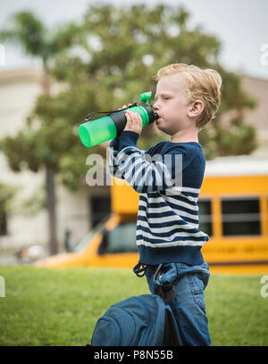 Boy drinking from bottle Banque D'Images