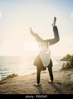 Man doing handstand on beach Banque D'Images