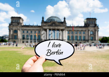 Libre de la main d'un jeune homme de race blanche montrant une bulle avec le texte que j'aime Berlin écrit en C, en face du bâtiment du Reichstag dans Banque D'Images