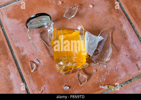 Pot de verre brisé de la marmelade sur plancher de tuiles Banque D'Images