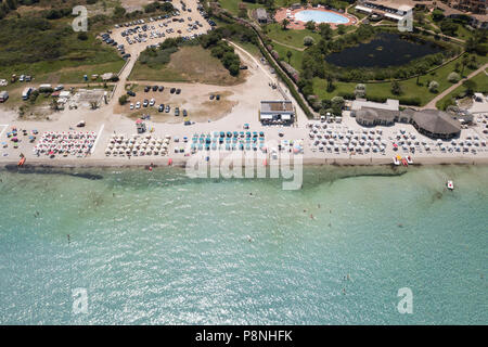 Vue aérienne de l'incroyable plage aux eaux turquoises et transparentes de la mer. Et les gens qui parasols colorés nagent en Sardaigne, mer Méditerranée, l'Italie. Banque D'Images