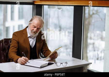 Senior business man s'occupe de comprimé dans le bureau moderne avec fenêtre de panorama Banque D'Images