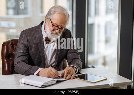 Ancien patron roi assis dans le bureau avec fenêtre de panorama.auto-développement au cours de la vieillesse Banque D'Images