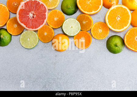 La vie de la frontière toujours mixte frais colorés d'agrumes avec des oranges, pamplemousse, clémentine, citron vert et de citron sur un fond blanc gris texturé wi Banque D'Images