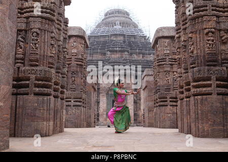 L'odissi est l'une des huit formes de danse classique de l'Inde, de l'état d'odisha.ici le danseur pose avant de temples avec sculptures Banque D'Images