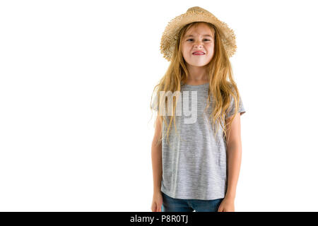 Petite fille blonde espiègle dans un quartier branché chapeau de paille convertible à l'appareil photo avec un sourire isolated on white Banque D'Images