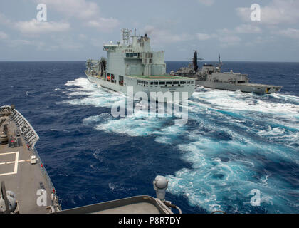 180711-N-A245-0558 de l'OCÉAN PACIFIQUE (Juillet 11, 2018) de classe Ticonderoga croiseur lance-missiles USS Lake Champlain (CG 57) méthodes d'approvisionnement de la Marine royale du Canada, le MV Astérix avec la frégate chilienne CNS Almirante Lynch (FF 07) aux côtés d'un ravitaillement en mer au cours de la formation approche de Rim of the Pacific (RIMPAC) Le 11 juillet. Vingt-cinq nations, 46 navires et 5 sous-marins, et d'environ 200 avions et 25 000 hommes participent de l'exercice RIMPAC 2008 du 27 juin au 2 août dans et autour des îles Hawaï et la Californie du Sud. Le plus grand exercice maritime international RIMPAC, fournit Banque D'Images