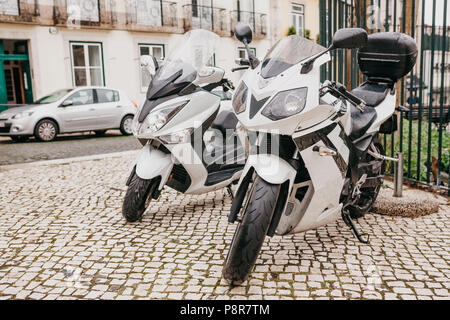 Parking gratuit dans la rue à Lisbonne au Portugal en temps de pluie. Deux motos sont garées à proximité. Une voiture est garée à l'arrière-plan. Banque D'Images