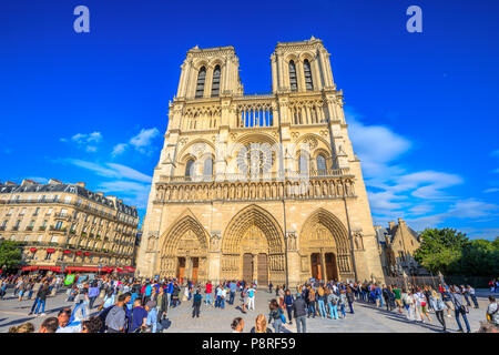 Paris, France - 1 juillet 2017 : de nombreux touristes dans square de Notre Dame de Paris, Ile de la Cite, pendant qu'ils attendent pour visiter la célèbre église gothique. Journée ensoleillée, ciel bleu. Façade principale de la Cathédrale de Paris. Banque D'Images