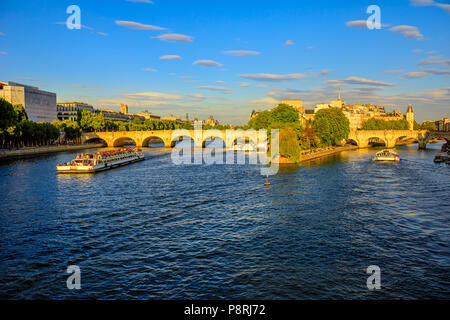 Croisière touristique sur la Seine. Bateau-mouche du Pont Neuf et Eglise Notre Dame sur l'arrière-plan. Les voyageurs de tourisme dans les monuments de Paris en France au coucher du soleil depuis le Pont des Arts pont. Banque D'Images