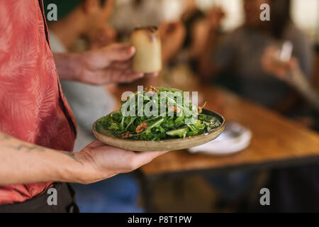 Waiter serving une salade saine au restaurant les clients Banque D'Images