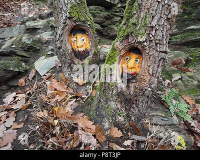 Visages de femme sculptée dans le tronc d'un arbre dans la forêt de Bensberg, Cologne Banque D'Images