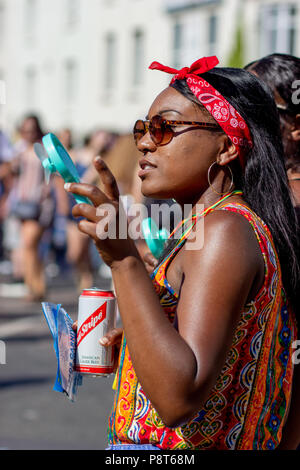 Woman gesturing tout en maintenant un ventilateur de poche au St Paul's Carnival, Bristol Banque D'Images