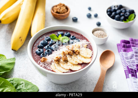 Smoothie Acai bowl surmontée de la banane, de semences chia, myrtilles, noix et noix de coco. Concept de la saine alimentation, mode de vie sain, les régimes amaigrissants, de désintoxication et de v Banque D'Images