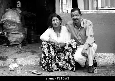 L'âge moyen pauvre couple tsigane turc -roms- assis sur le trottoir en face d'un bidonville en chambre hotel Kalemi Kagithane Istanbul Turquie Banque D'Images