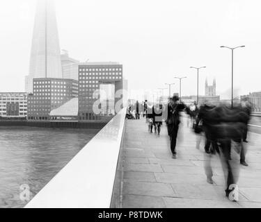 Lundi matin, les navetteurs au travail à pied sur le pont de Londres sur la Tamise et vers la ville et le Fragment d'un jour brumeux Banque D'Images