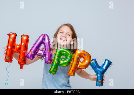 Cheerful girl avec des ballons anniversaire lettres Banque D'Images