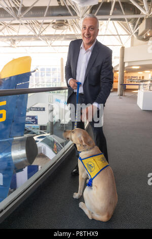 Garden City, New York, USA. 21 juin, 2018. La navette spatiale de la NASA L'astronaute Mike MASSIMINO pose avec un chien de compagnie de Canine Companions for Independence, un organisme sans but lucratif Medford, avant la conférence de Maximin au berceau de l'Aviation Museum. Conférence gratuite fait partie du compte à rebours du musée d'Apollon à 50, la célébration du 50e anniversaire de l'alunissage d'Apollo 11 le 20 juillet 1969. Banque D'Images
