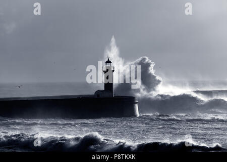 Grosse Vague spectaculaire rétroéclairé sur phare. Tons bleu. Banque D'Images